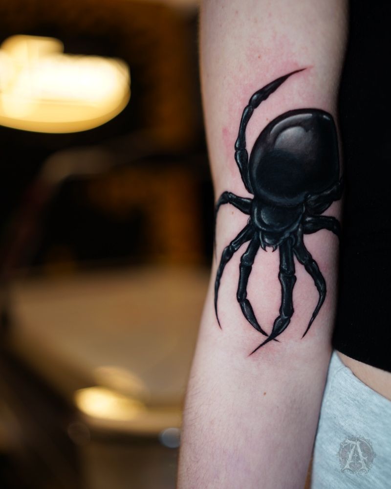 Tatuaje de araña en negro sólido en el brazo, blackwork en negro y gris