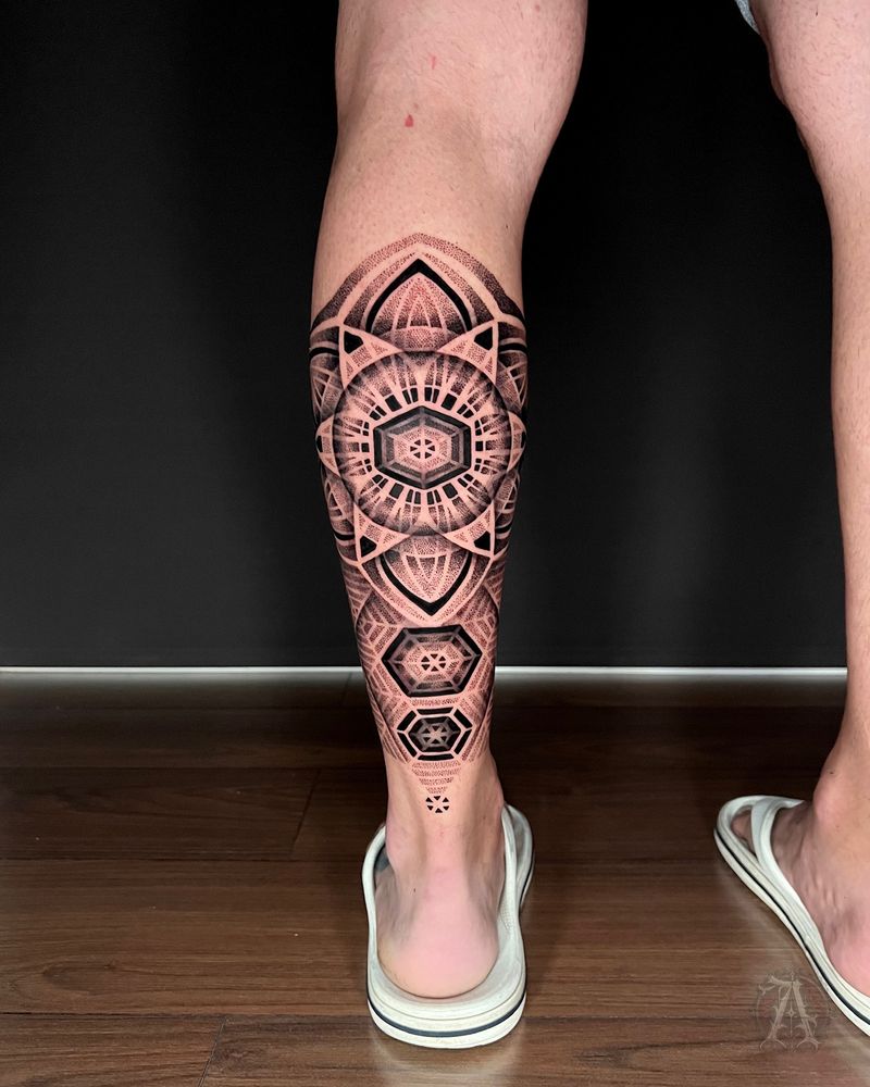 Tatuaje dotwork de mandala circular en el gemelo, puntillismo en negro