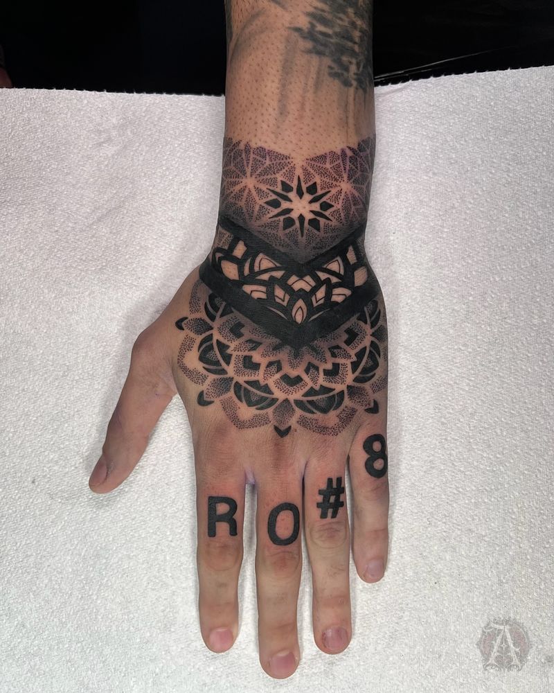 Tatuaje dotwork de mandala en el dorso de la mano, puntillismo en negro