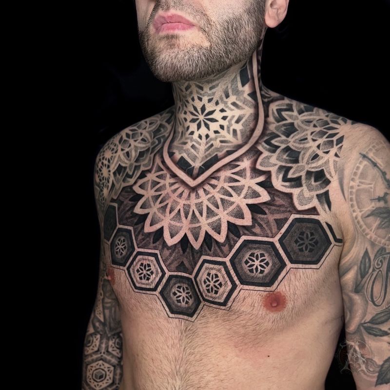Tatuaje dotwork de mandala geométrico en pecho y cuello, puntillismo en negro