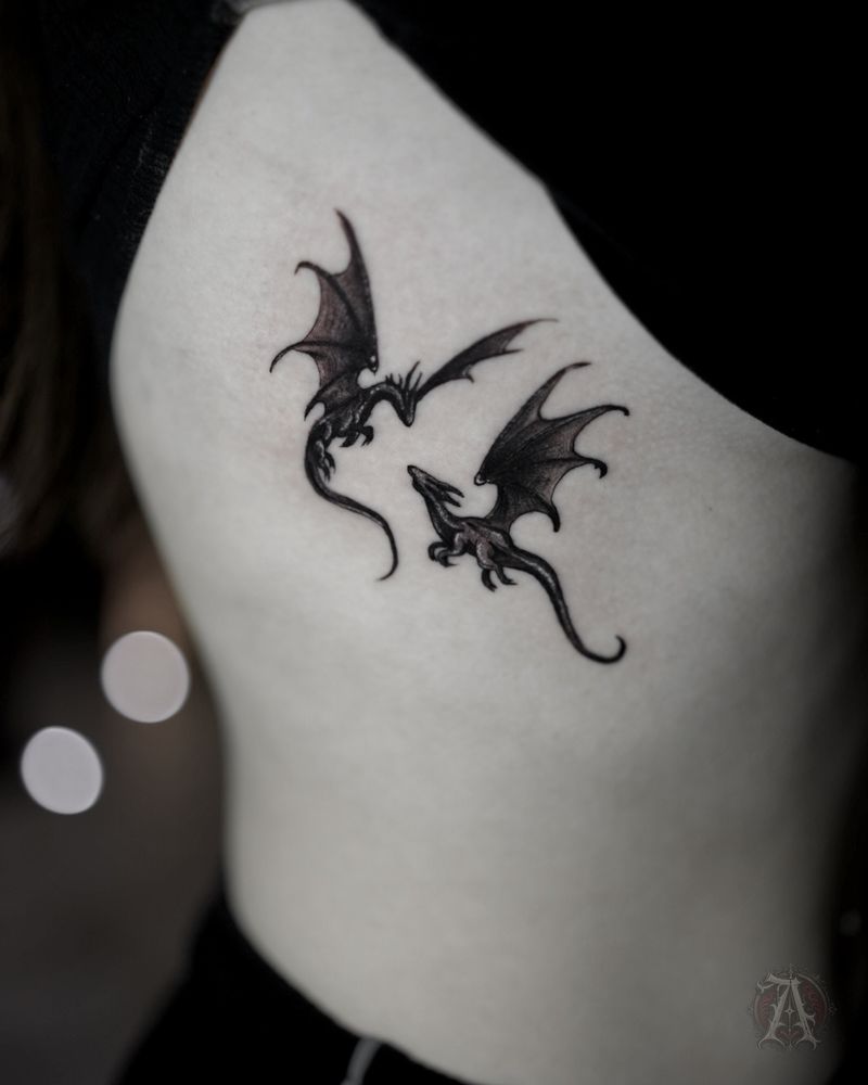 Tatuaje de dos dragones diminutos en las costillas, fine line en negro y gris