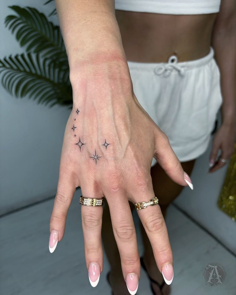 Tatuaje de estrellas en la mano en la mano, fine line en negro y gris