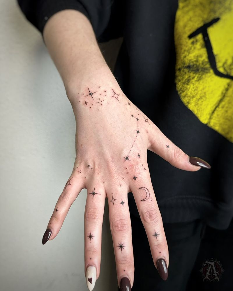 Tatuaje de estrellas y puntos en la mano y los dedos, fine line en negro y gris