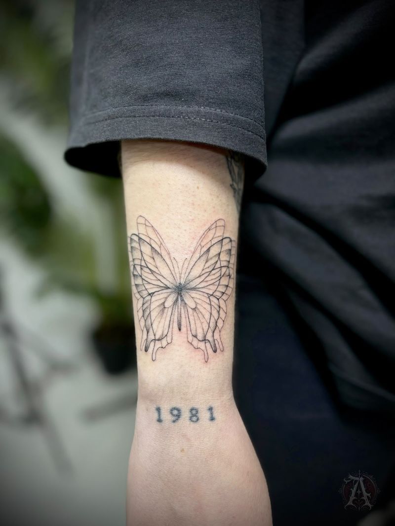 Tatuaje de mariposa y año en la muñeca, fine line en negro y gris