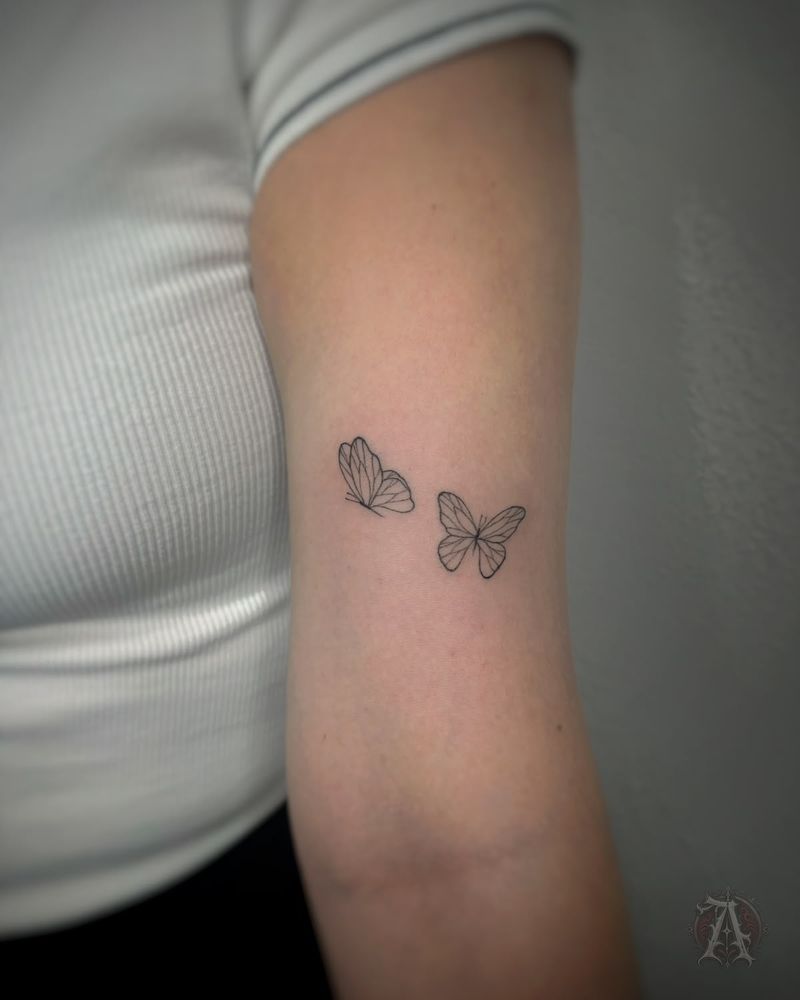 Tatuaje de mariposas en vuelo en el tríceps, fine line en negro y gris