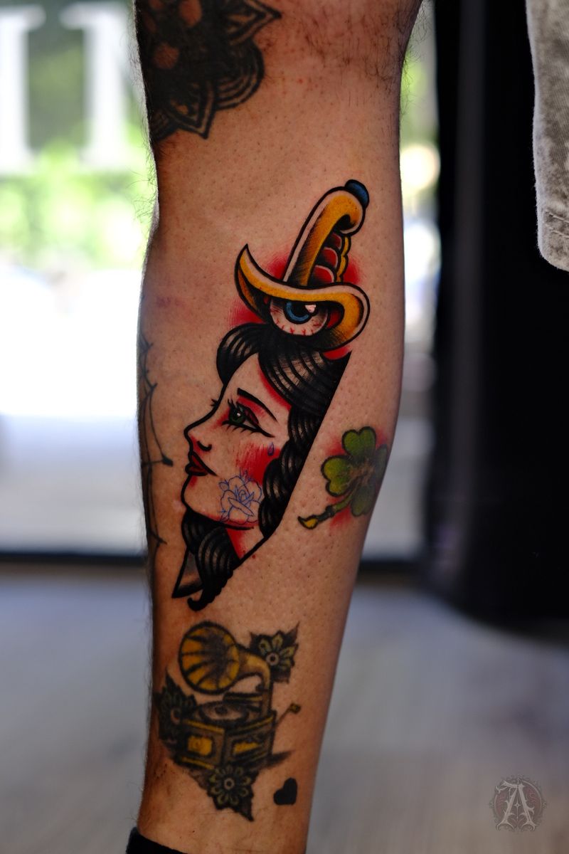 Tatuaje de pin-up y daga en la pierna, neo-tradicional con color
