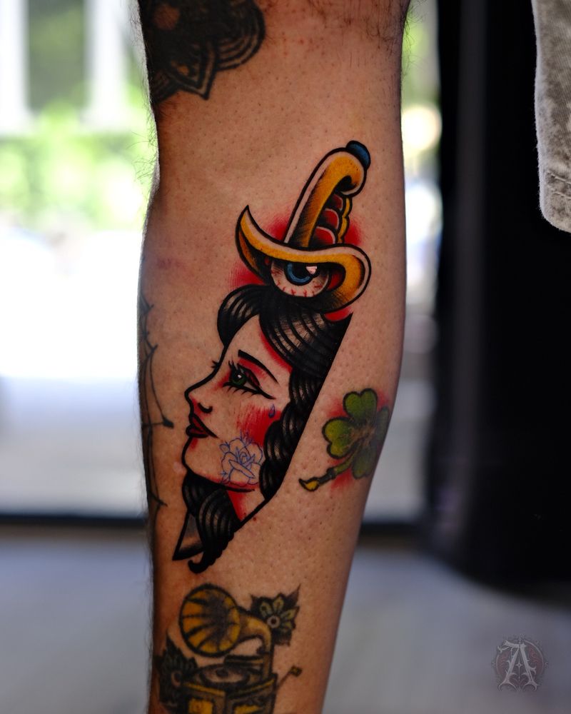 Tatuaje de pin-up y daga en la pierna, neo-tradicional con color